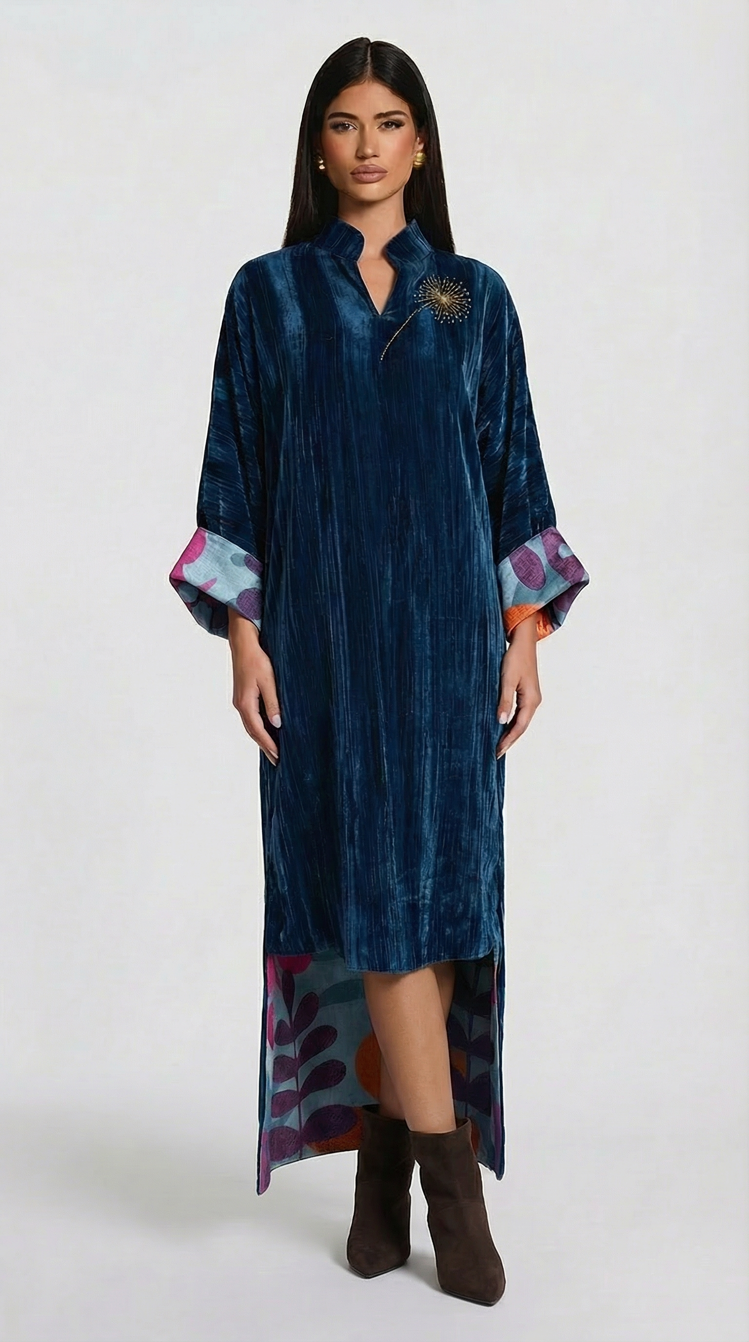 Woman wearing a blue velvet dress with colorful cuffs on a white background