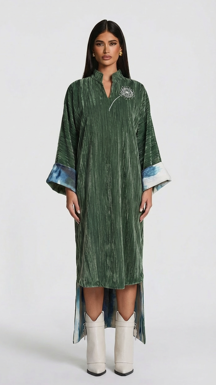 Woman wearing a green patterned dress with white boots on a white background