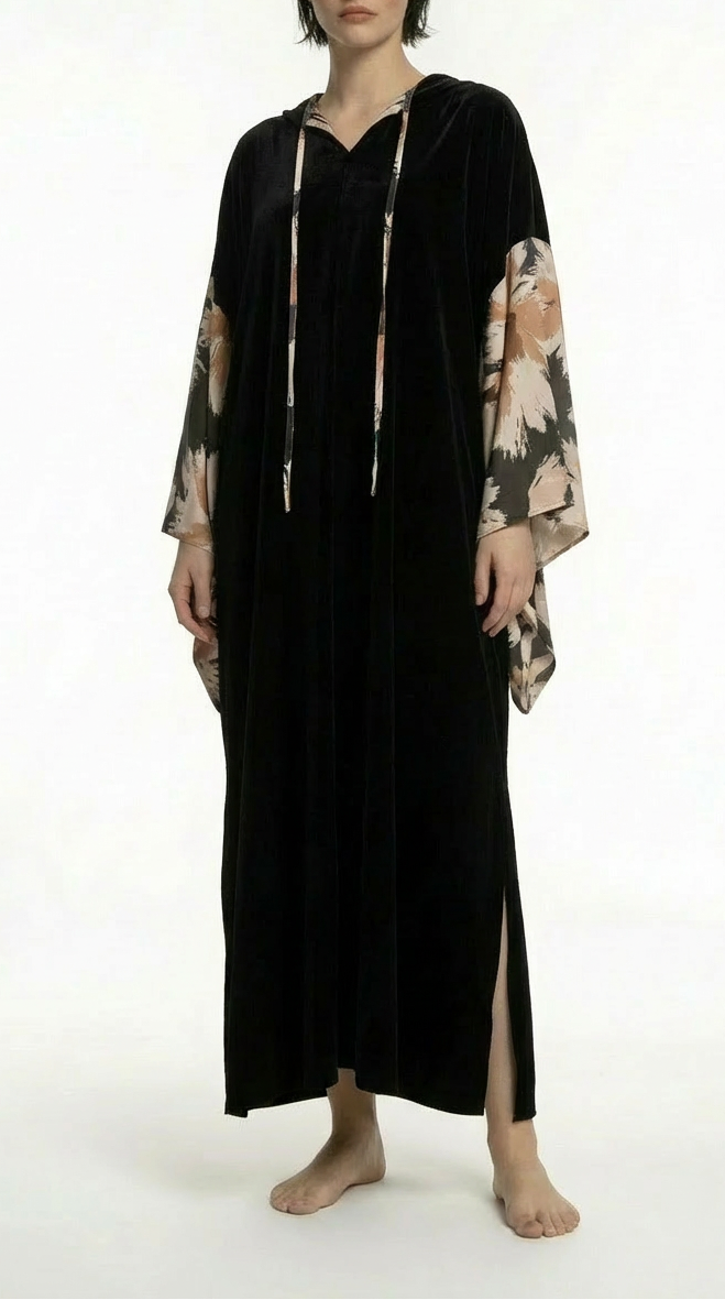 Woman wearing a black dress with floral sleeves on a white background