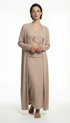 Woman wearing a beige long-sleeve top and skirt set on a white background