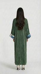 Person wearing a green textured dress with white shoes on a white background